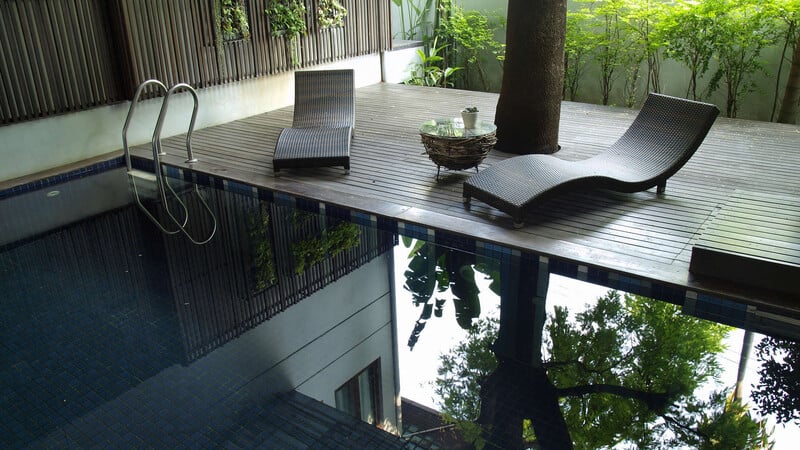 Terrasse avec piscine et chaises longues modernes - Hôtel Spa Alsace