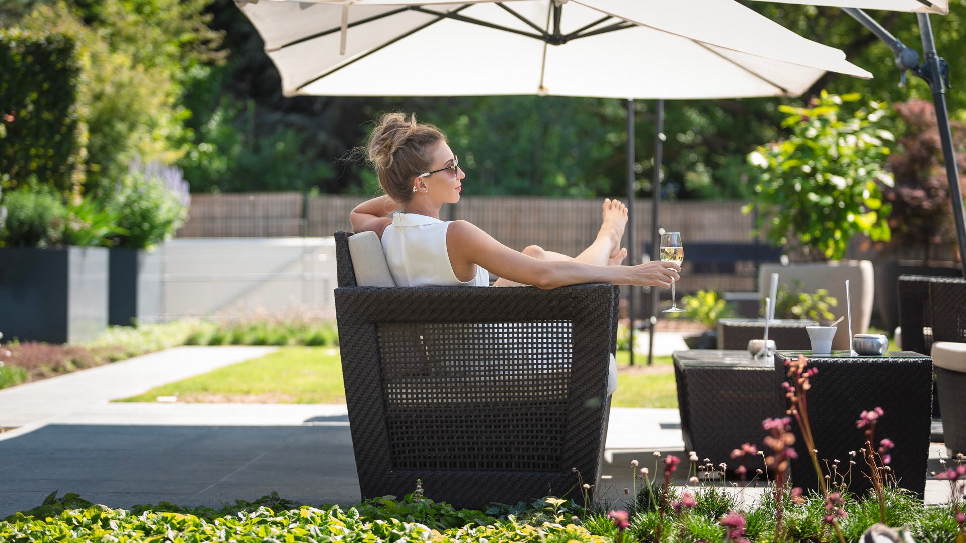 Femme détendue sur terrasse avec verre de vin - Hôtel Spa Alsace