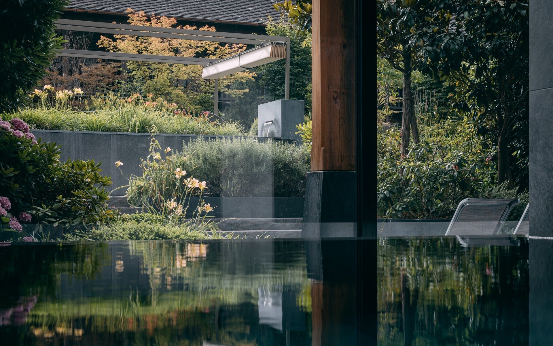 Piscine intérieure avec vue sur jardin luxuriant.