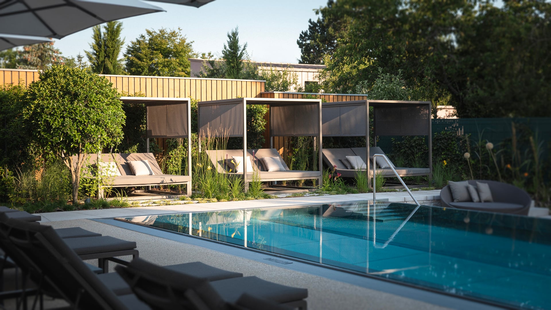 Piscine avec transats et cabanes.