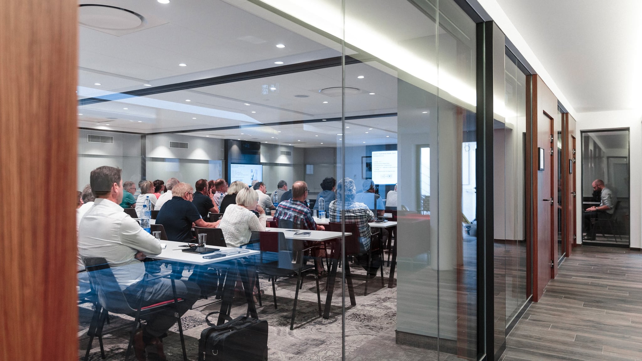 Réunion avec participants dans une salle de conférence.