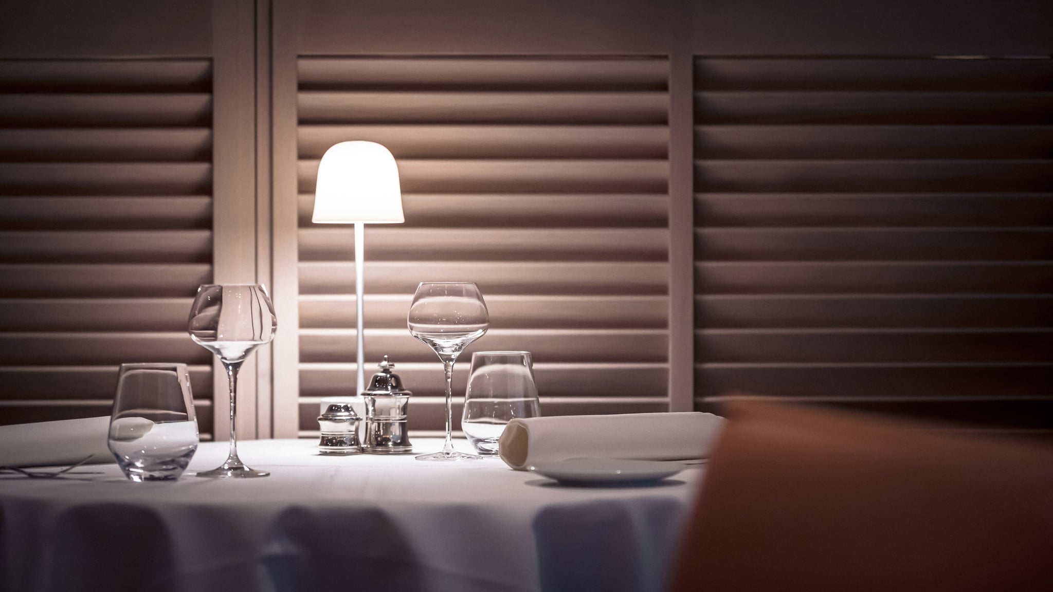 Table de restaurant élégante avec verres et lampe.