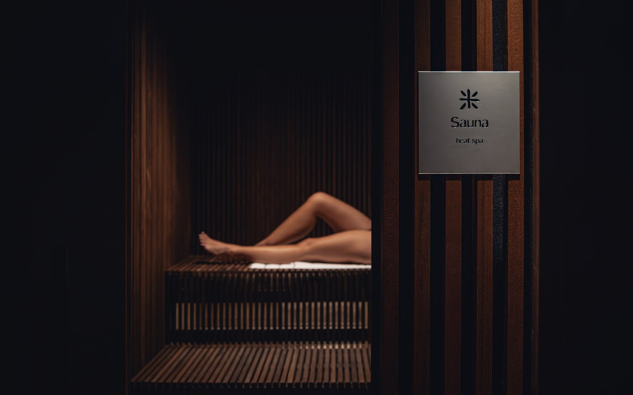 Personne allongée dans un sauna en bois.