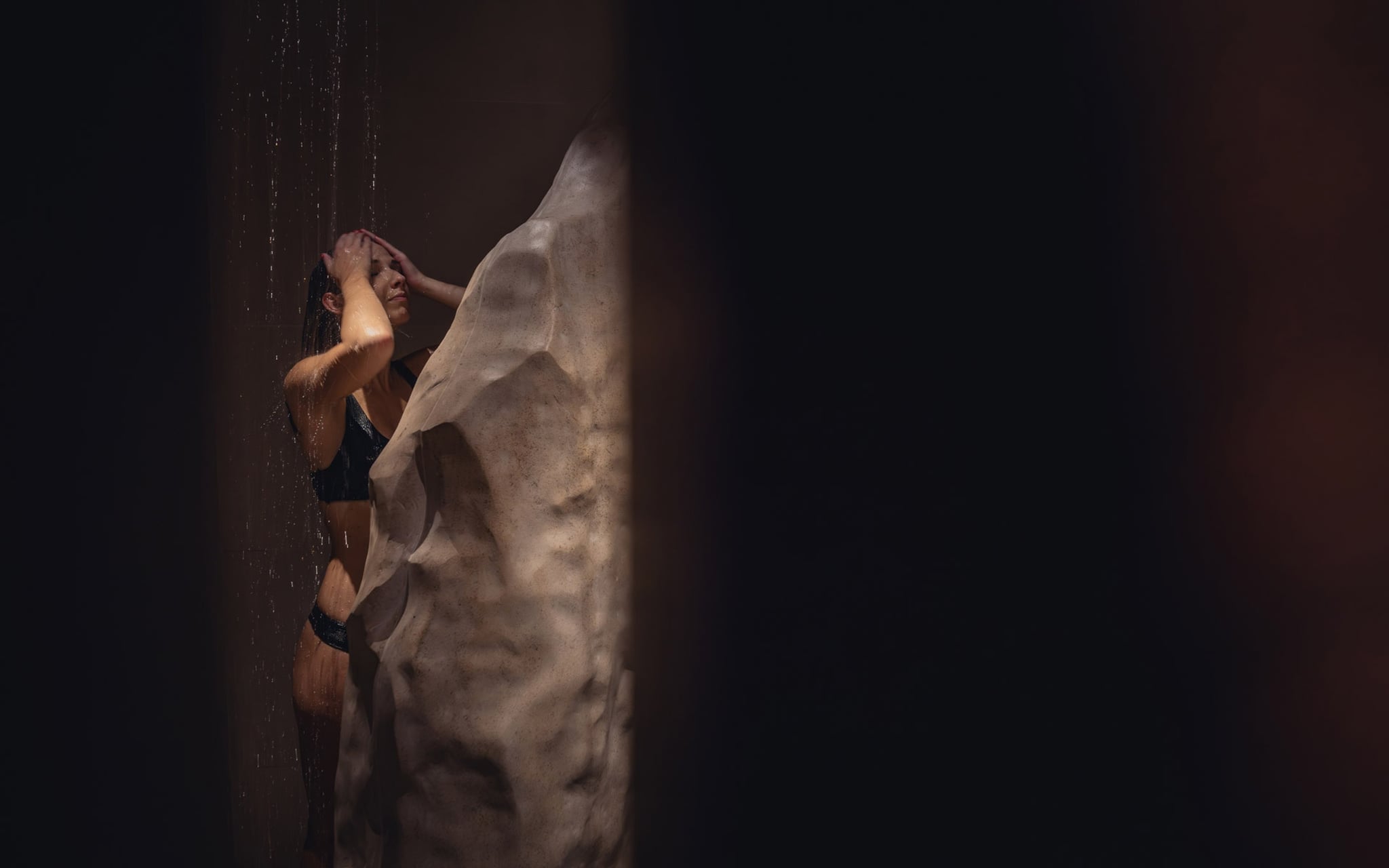 Personne sous douche rocheuse.