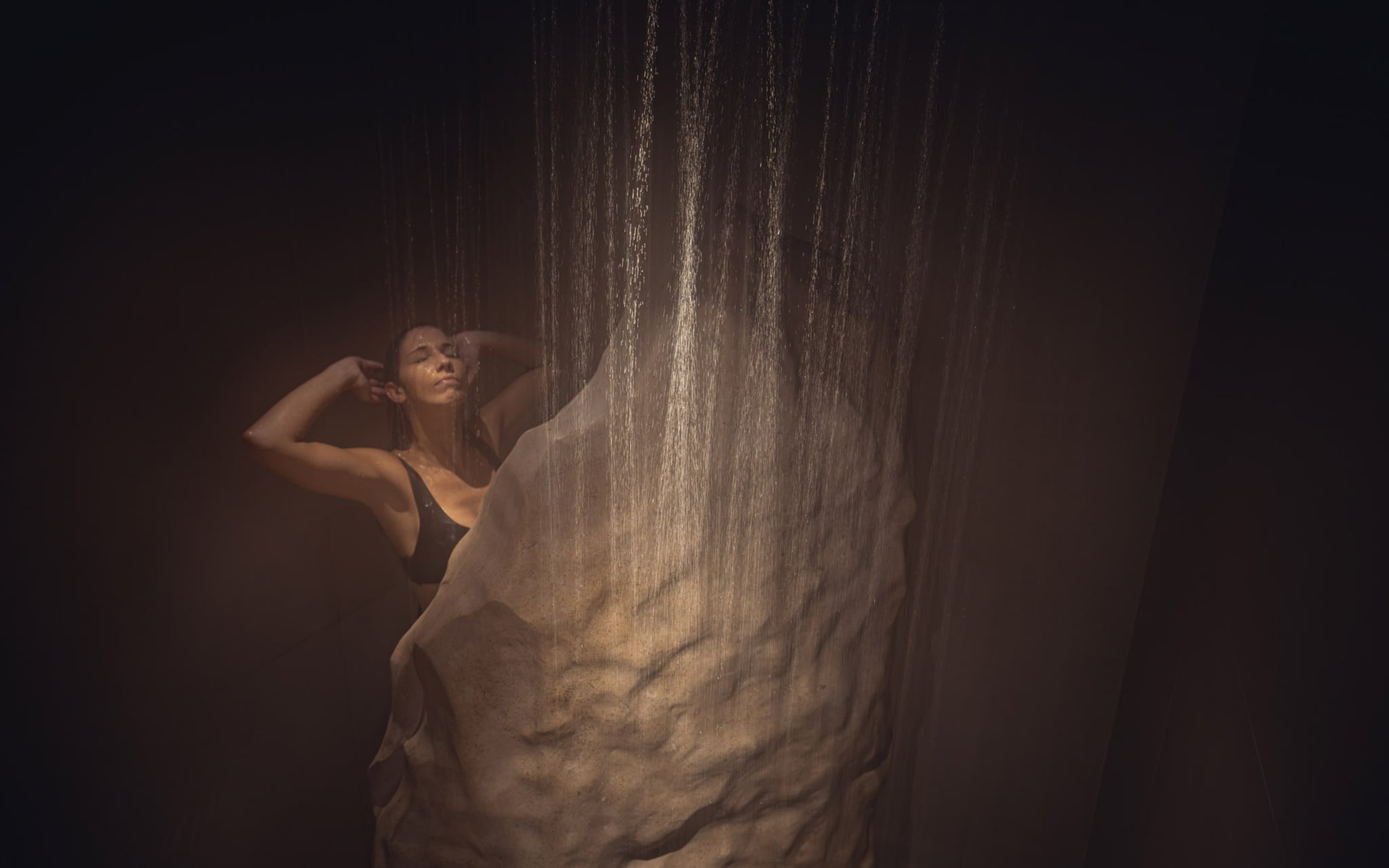 Femme sous une cascade d'eau