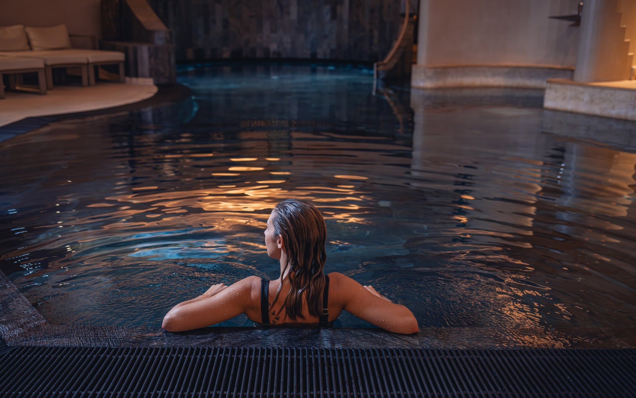 Femme se relaxant dans une piscine intérieure.