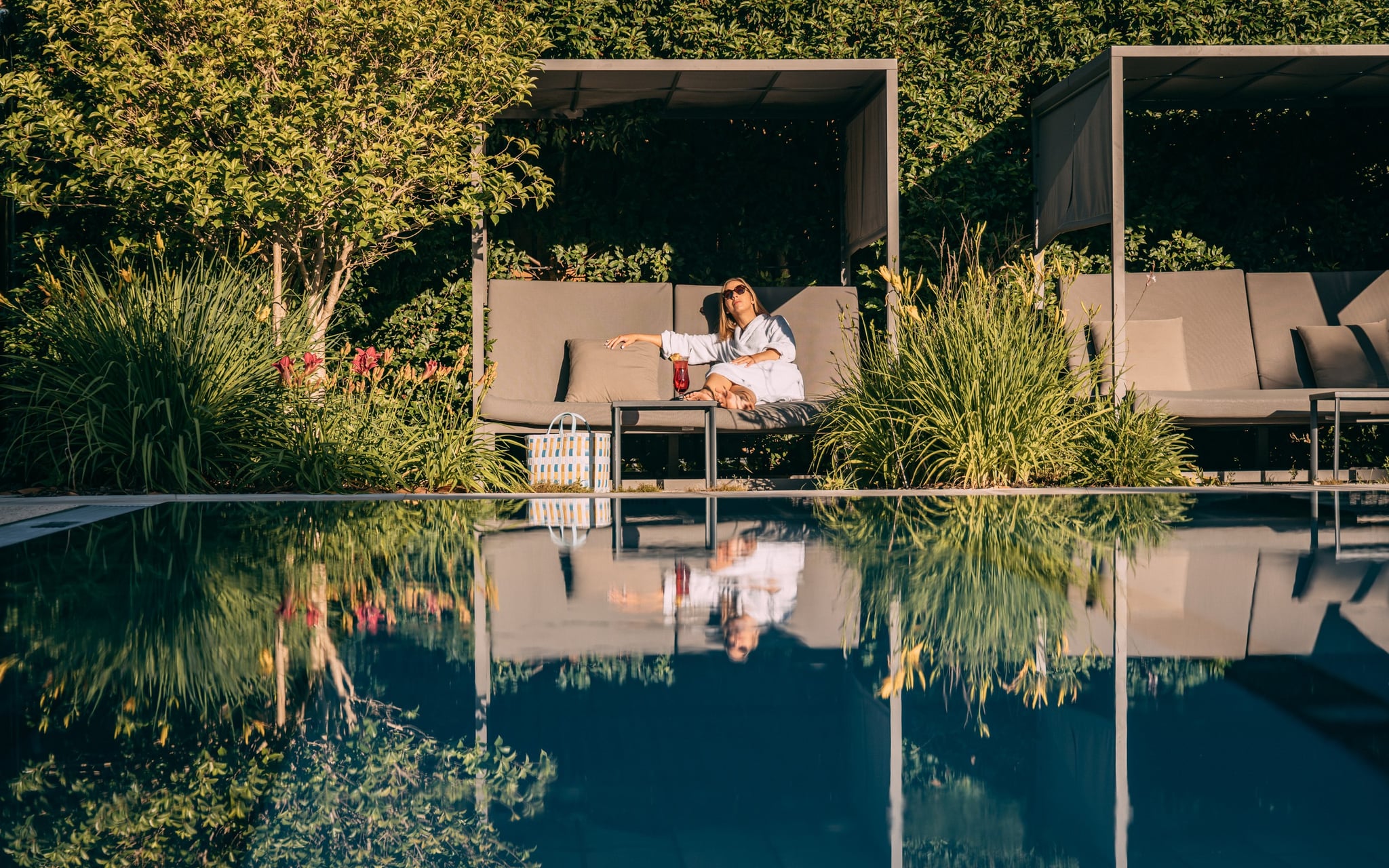 Femme relaxant près d'une piscine moderne.