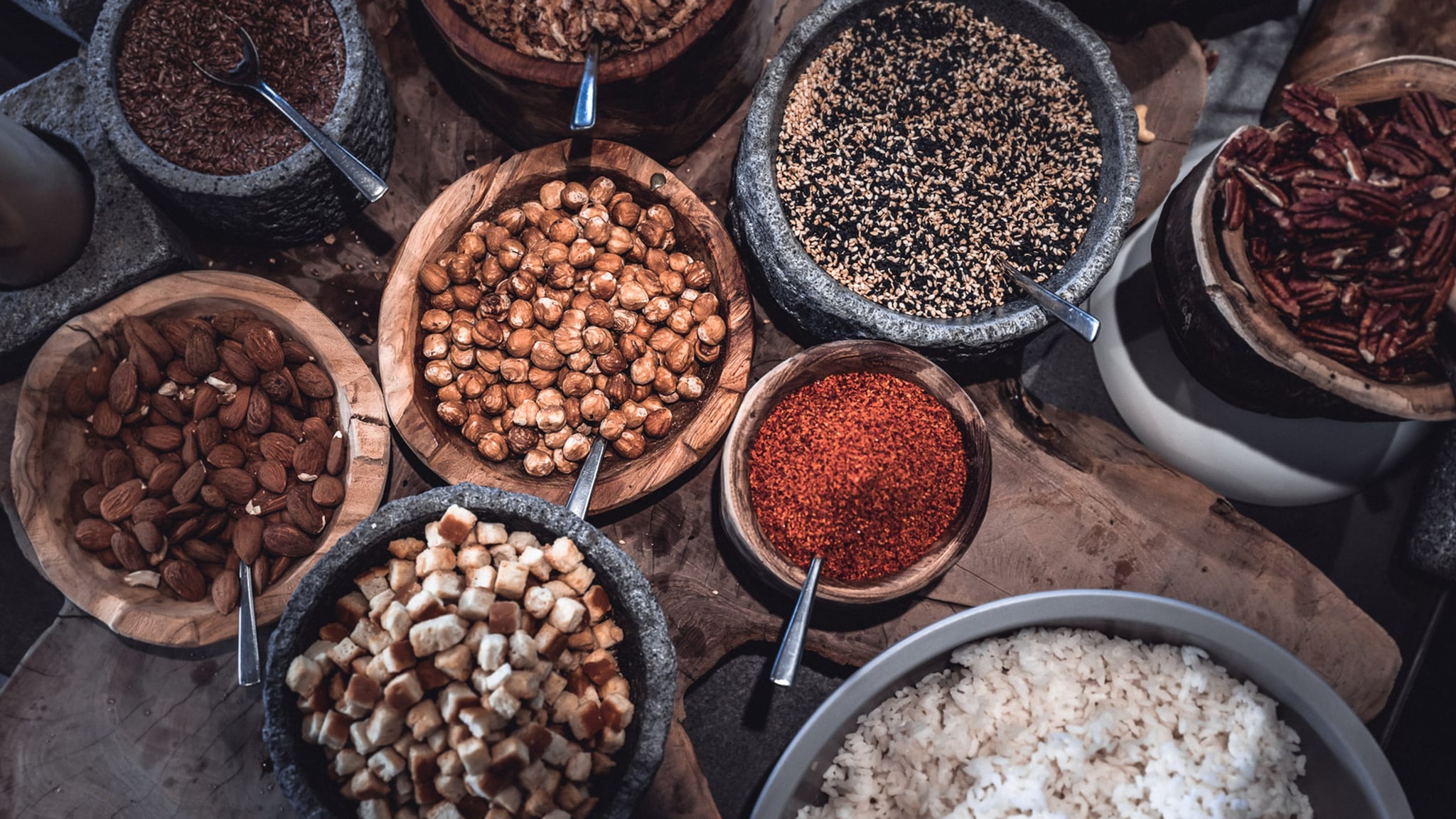 Assortiment de noix et graines en bols rustiques.