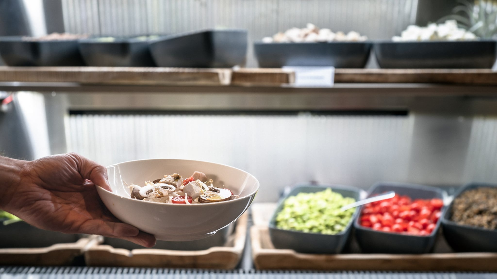 Main tenant un bol de salade fraîche.