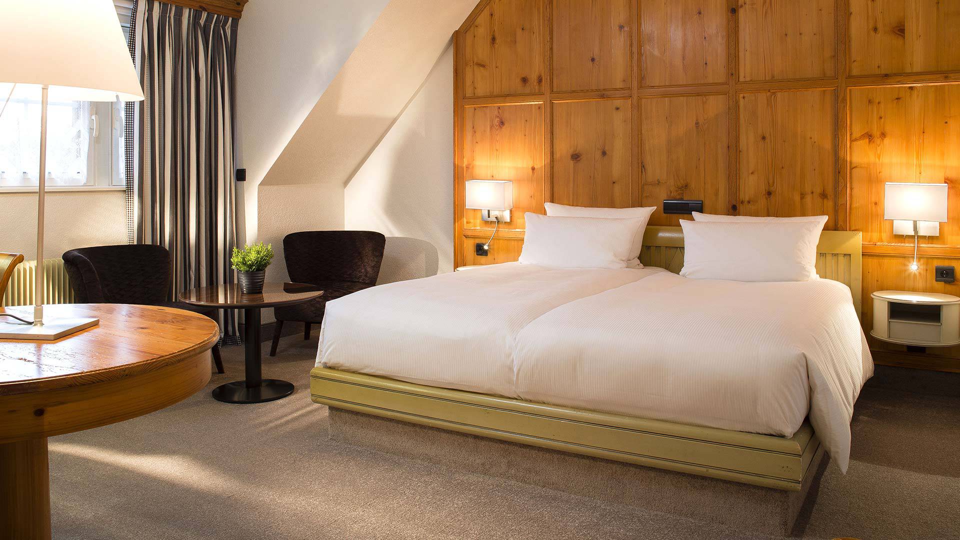 Chambre d'hôtel avec lit double et mobilier en bois.