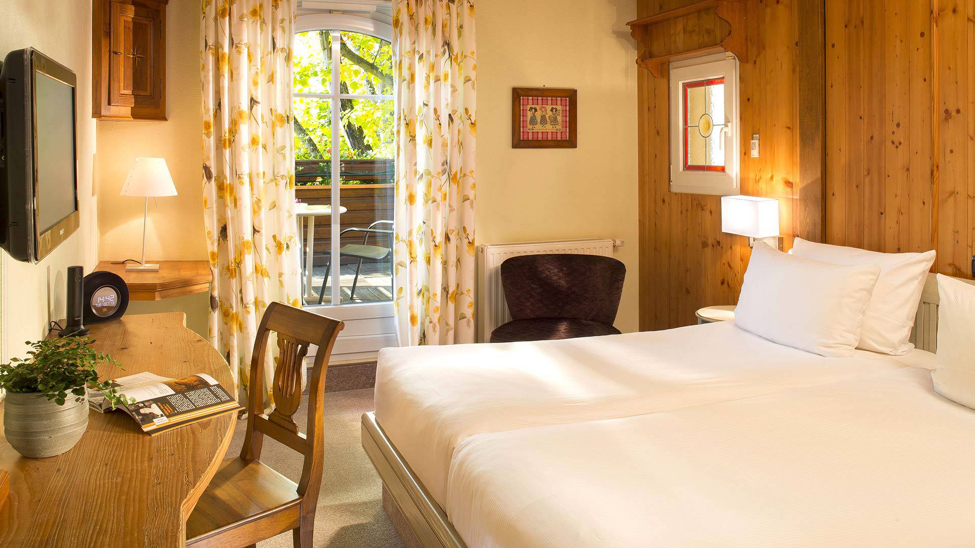 Chambre lumineuse avec balcon et décoration en bois.