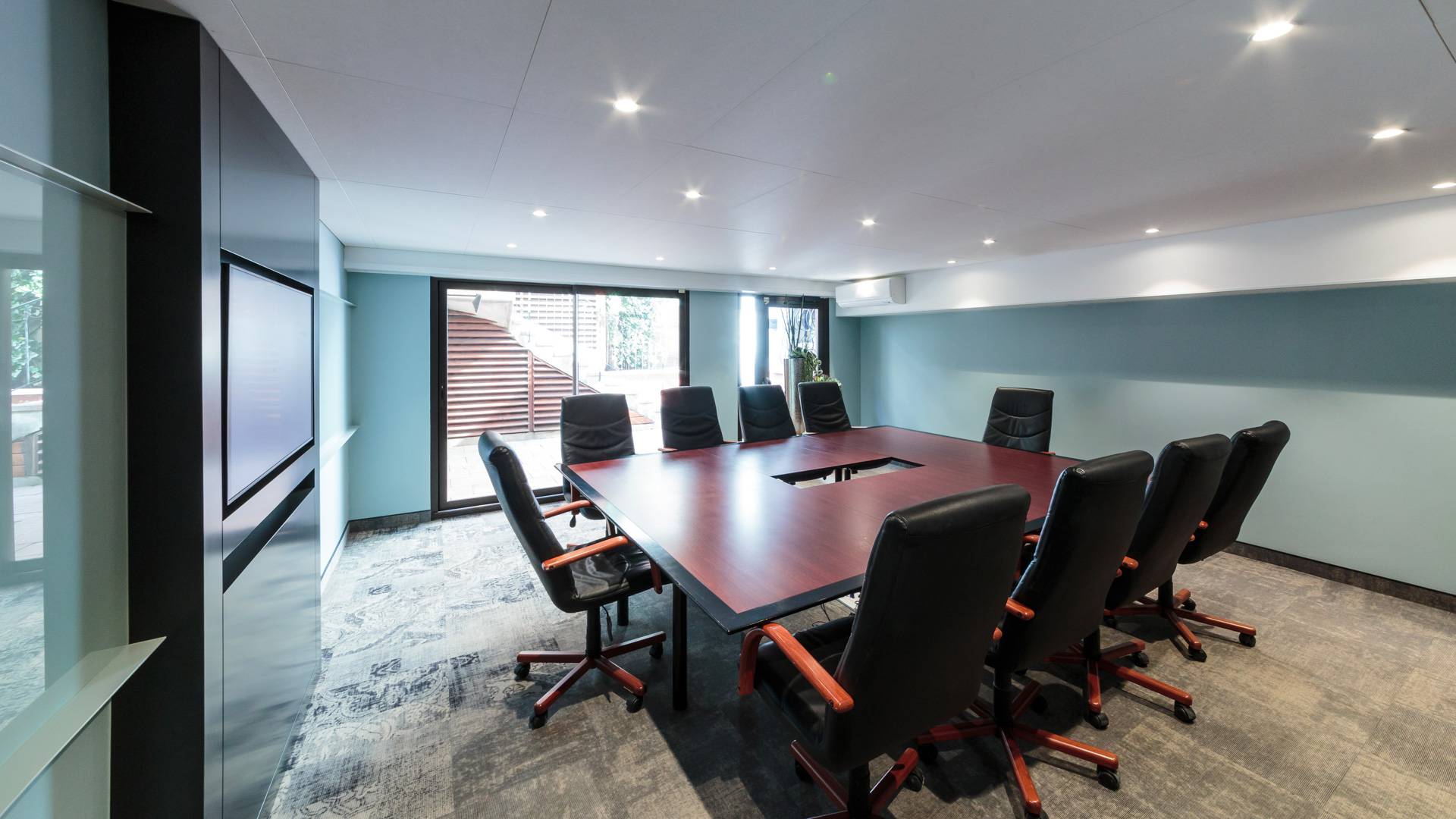Salle de réunion moderne avec chaises noires.