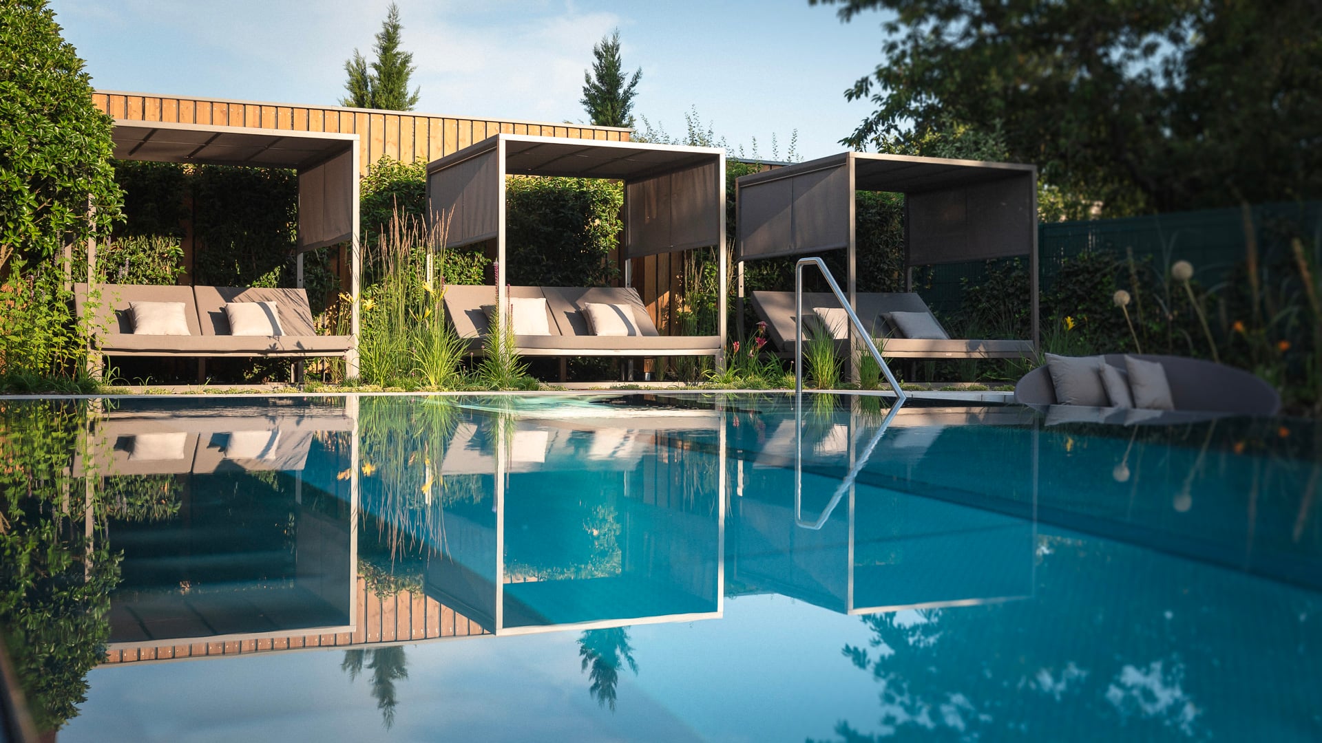 Piscine extérieure avec lits de repos modernes.