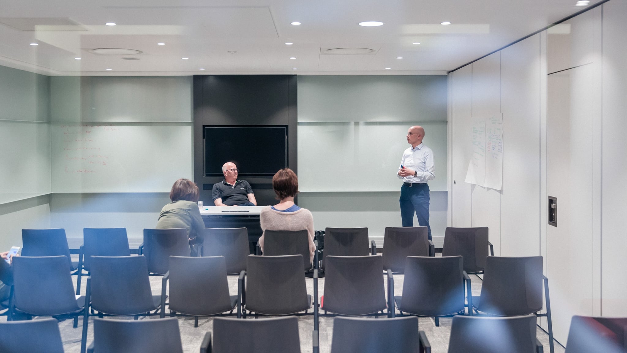 Réunion dans une salle vide, discussions en cours.